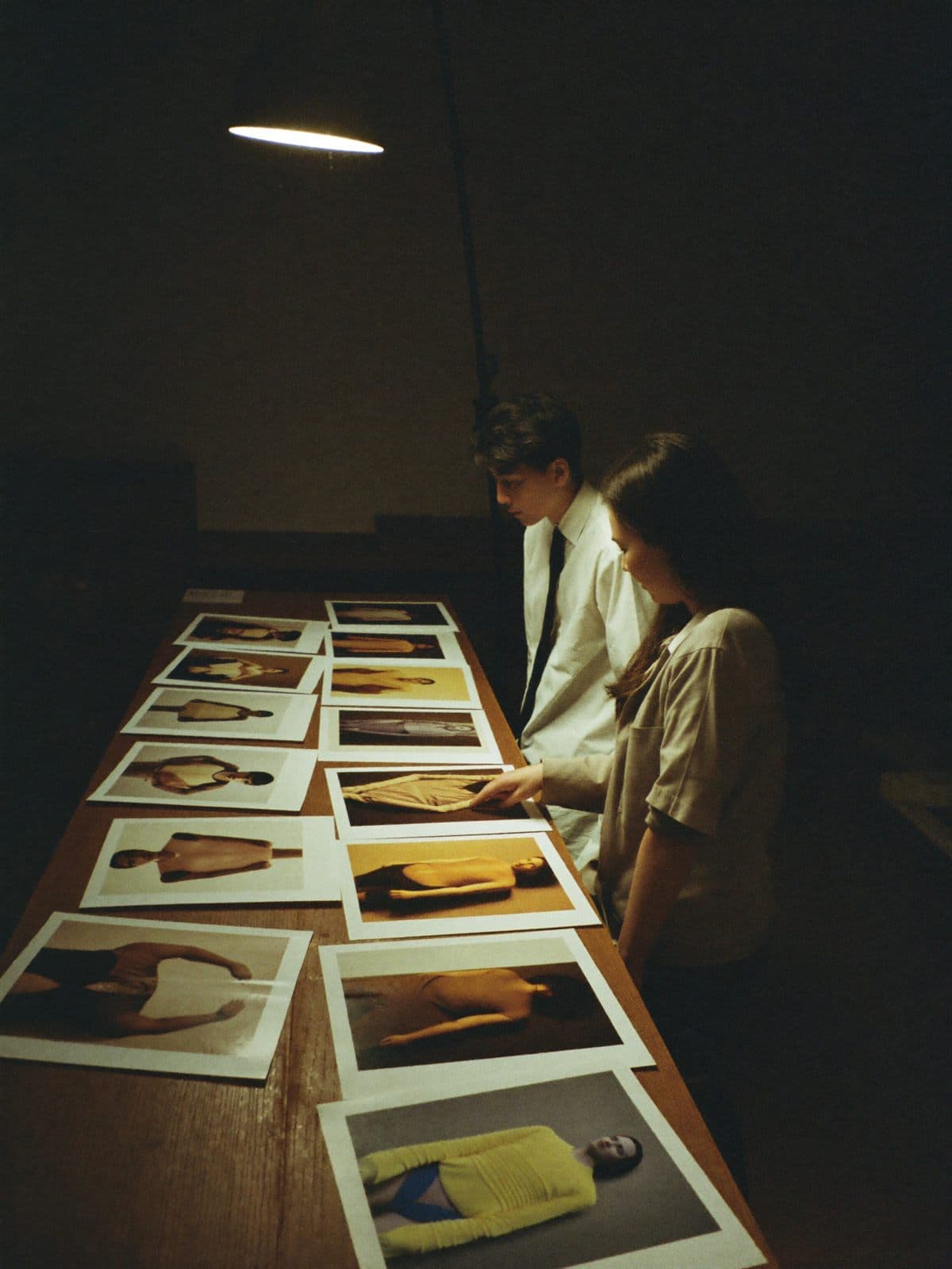 A photography teacher reviewing prints with a student